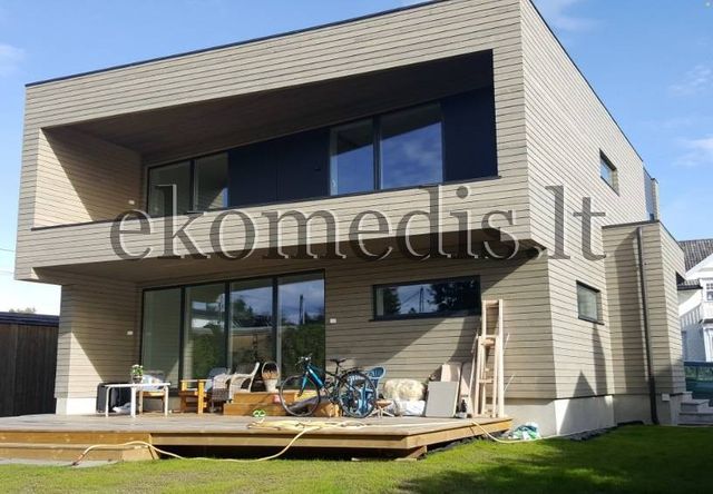 Moderne toetasjes trehus med liggende kledning, flatt tak, innfelt balkong og stor treterrasse