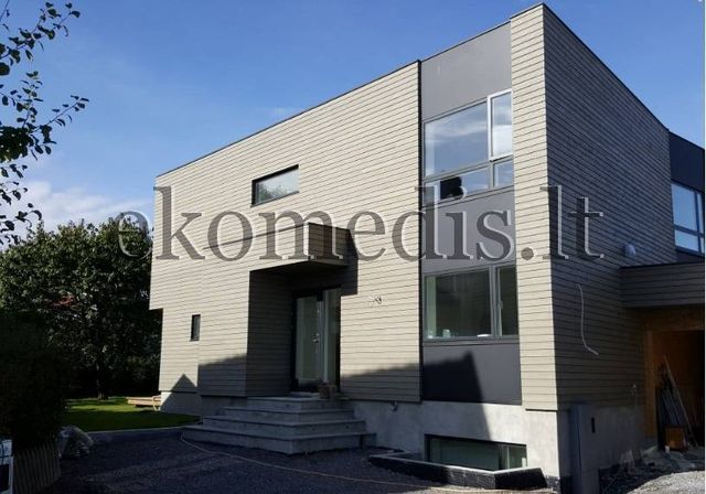 Inngangsparti på moderne hus med liggende trekledning, mørke fasadefelt og trapp opp til døren